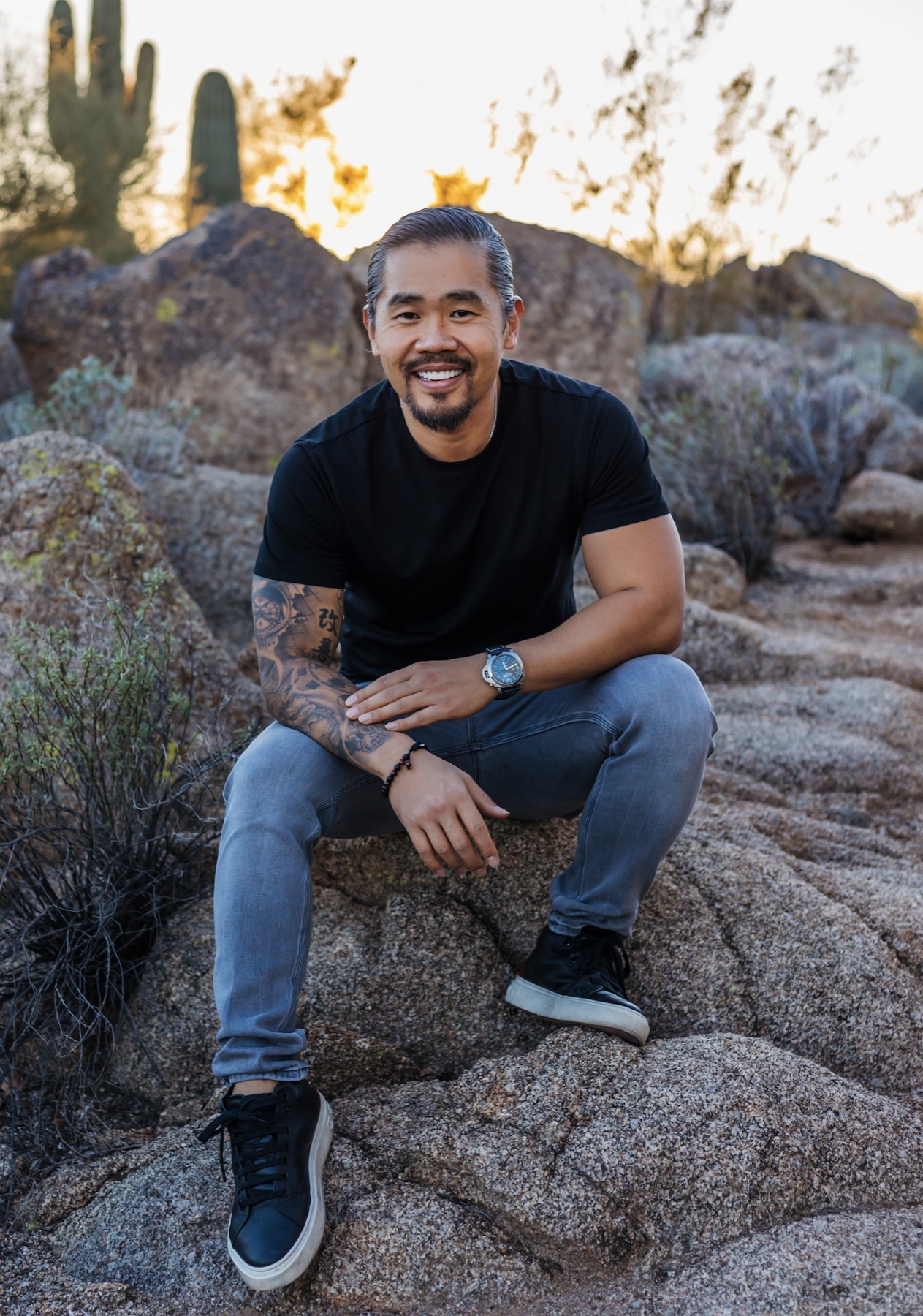 Terry Kim seated on desert rock at dusk